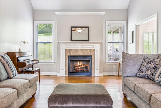 living room with lofted ceiling, a tile fireplace, and hardwood / wood-style flooring