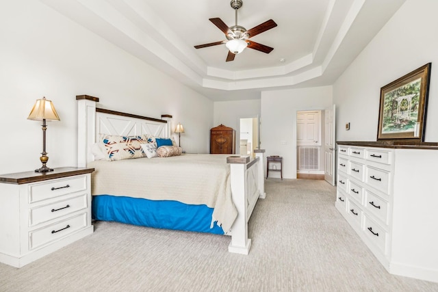 carpeted bedroom featuring ceiling fan and a tray ceiling