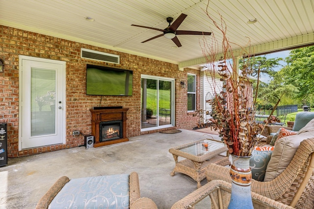 view of patio with ceiling fan and an outdoor fireplace