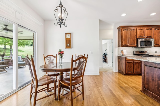 dining area featuring ceiling fan with notable chandelier, light hardwood / wood-style floors, and plenty of natural light