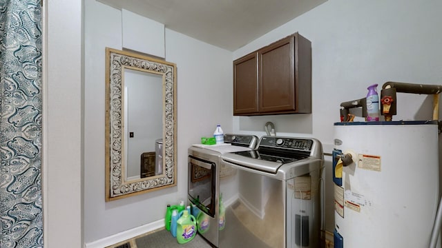 clothes washing area with water heater, washing machine and clothes dryer, and cabinets