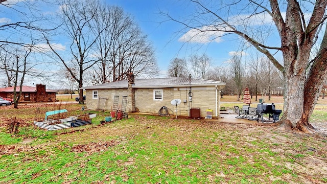 rear view of house featuring a patio and a lawn