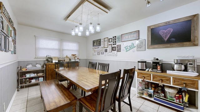 dining area with a chandelier and light tile patterned floors