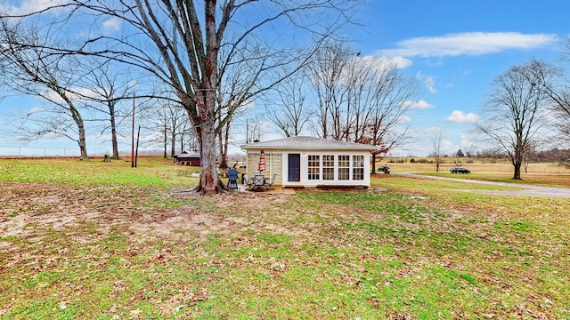 view of front facade featuring a rural view and a front lawn