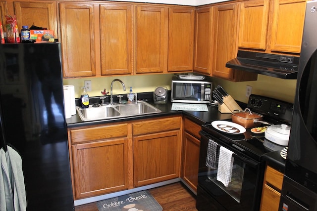 kitchen featuring dark wood-type flooring, black appliances, and sink