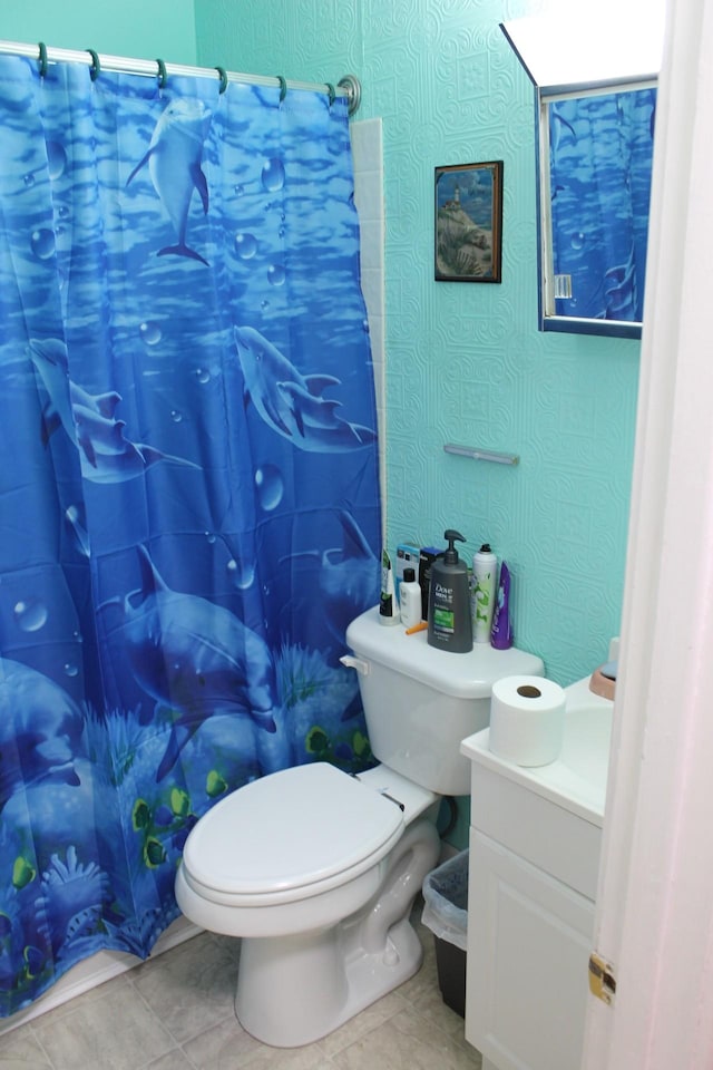 bathroom with toilet, vanity, tile patterned floors, and walk in shower