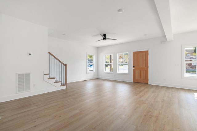 unfurnished living room with ceiling fan, light wood-type flooring, and beamed ceiling