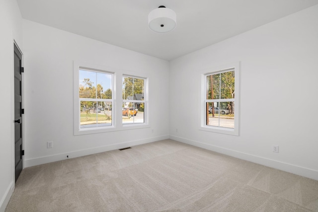 unfurnished room featuring light carpet