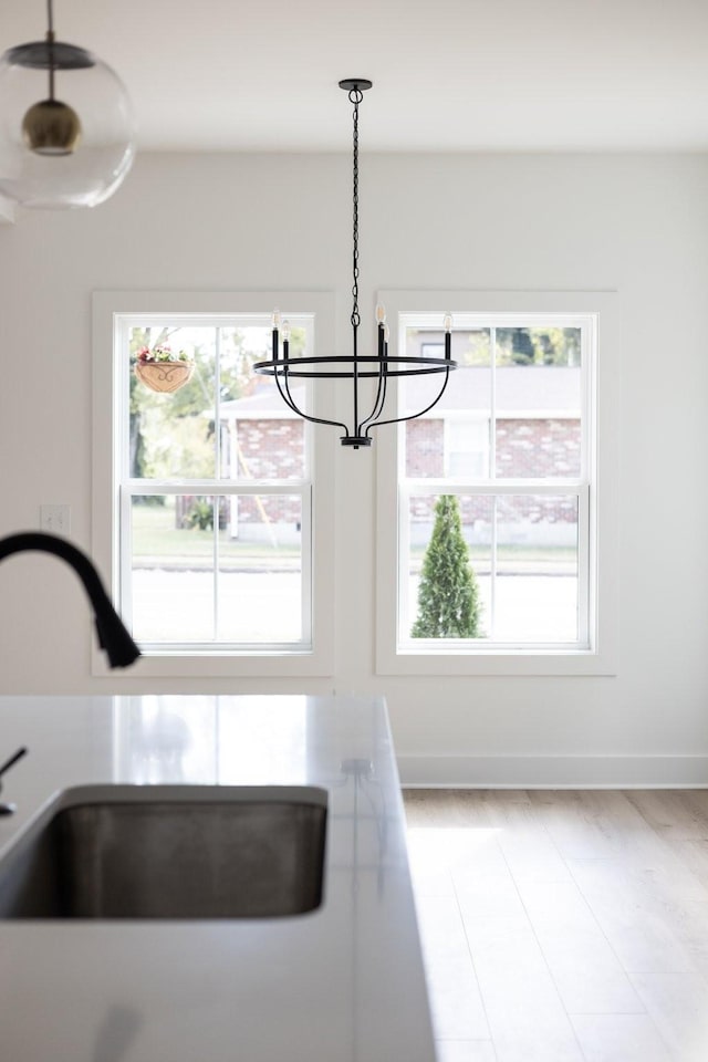 interior space with sink, a chandelier, a healthy amount of sunlight, and hanging light fixtures