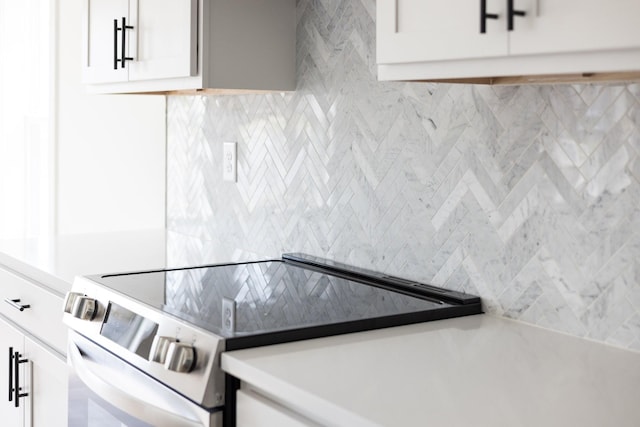 kitchen featuring stainless steel electric range oven and white cabinetry