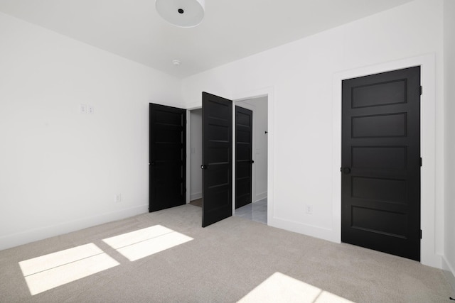 unfurnished bedroom featuring light colored carpet and a closet