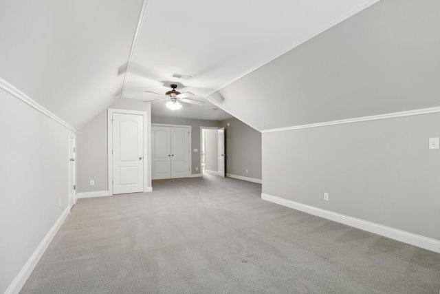 additional living space with ceiling fan, vaulted ceiling, and light carpet