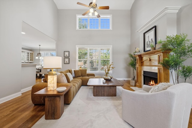 living room with a high ceiling, sink, ceiling fan, and hardwood / wood-style floors