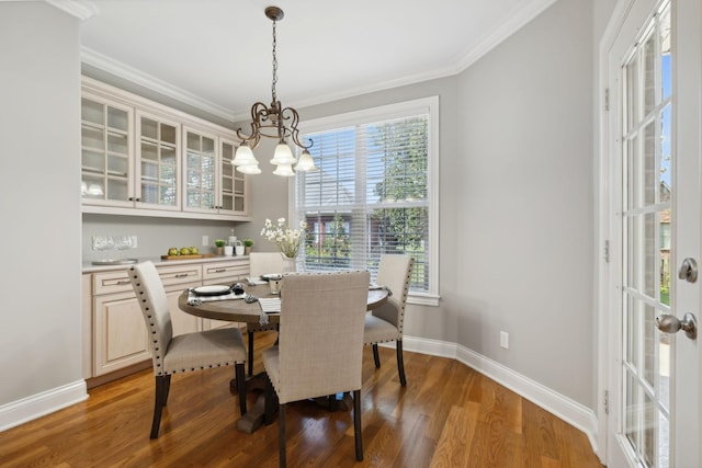 dining space with an inviting chandelier, crown molding, and hardwood / wood-style flooring