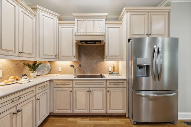 kitchen with ornamental molding, stainless steel fridge with ice dispenser, black electric cooktop, and tasteful backsplash