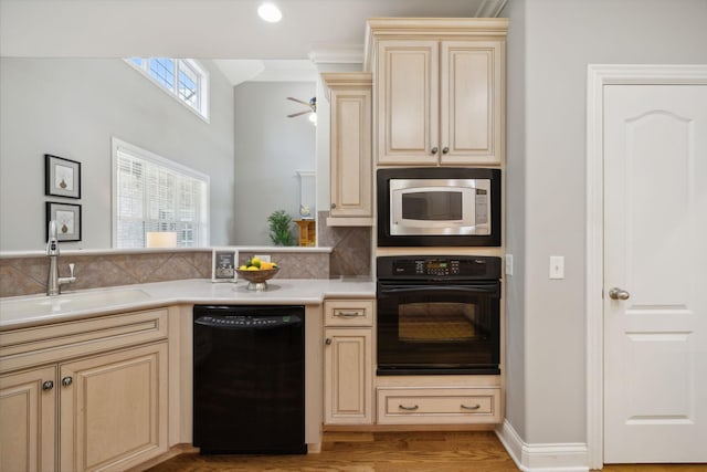 kitchen featuring sink, light wood-type flooring, black appliances, and crown molding