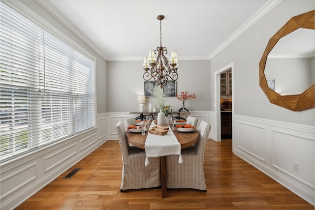 dining area featuring a healthy amount of sunlight, an inviting chandelier, and hardwood / wood-style flooring