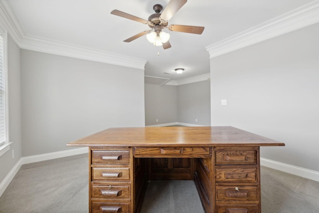 unfurnished office featuring built in desk, carpet flooring, ceiling fan, and crown molding