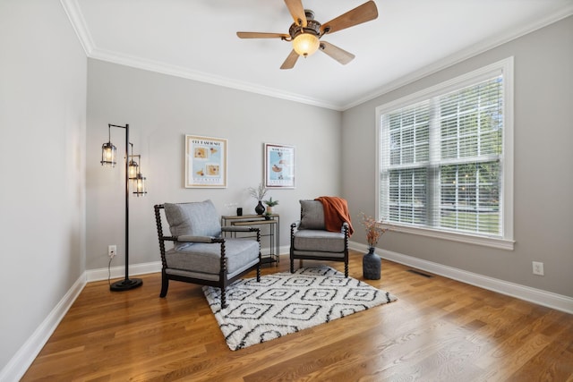 sitting room featuring ceiling fan, crown molding, and hardwood / wood-style flooring