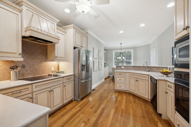 kitchen with black appliances, hanging light fixtures, light wood-type flooring, crown molding, and sink