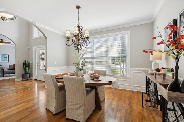 dining room featuring ceiling fan with notable chandelier, ornamental molding, hardwood / wood-style floors, and plenty of natural light