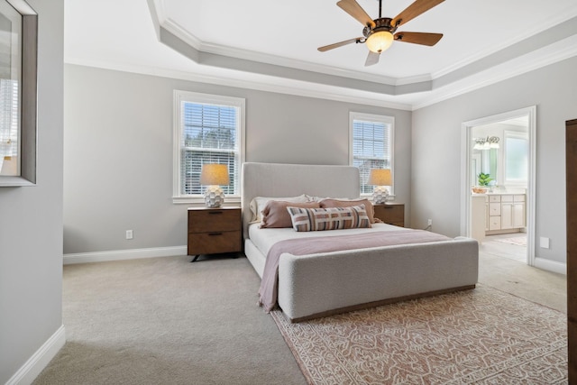 carpeted bedroom featuring ensuite bathroom, a raised ceiling, ceiling fan, and crown molding