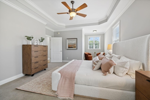 bedroom with a raised ceiling, ceiling fan, ornamental molding, and light colored carpet