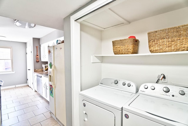 laundry room with washing machine and dryer and light tile patterned floors