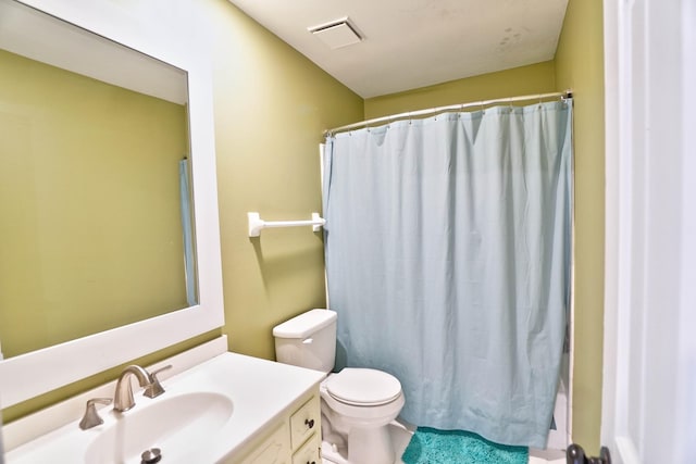 bathroom with curtained shower, vanity, and toilet