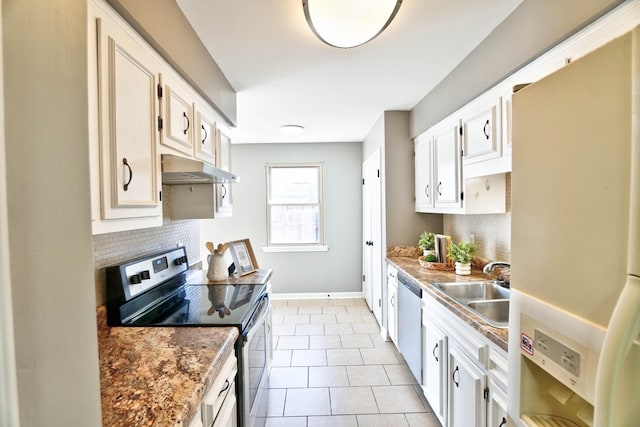 kitchen with light tile patterned flooring, appliances with stainless steel finishes, white cabinetry, sink, and backsplash