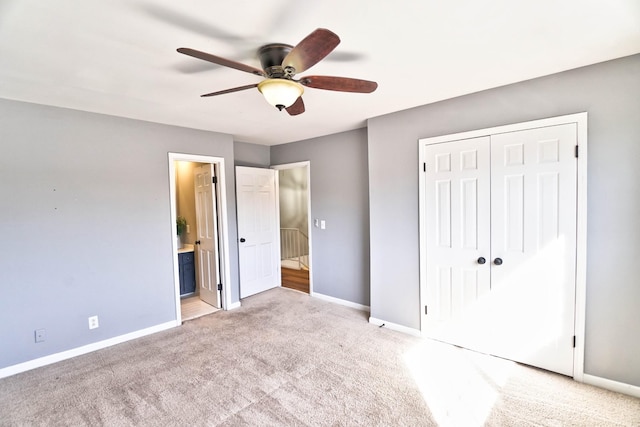 unfurnished bedroom featuring ceiling fan, light carpet, ensuite bath, and a closet