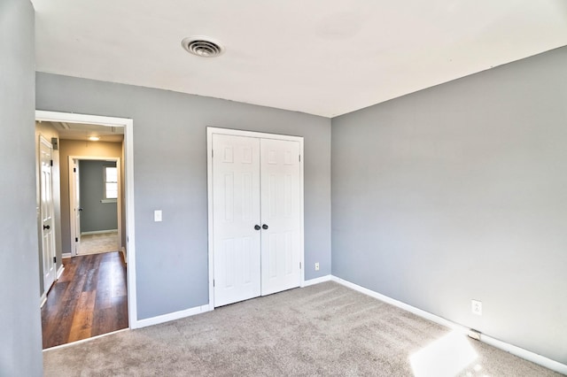 unfurnished bedroom with a closet and dark colored carpet