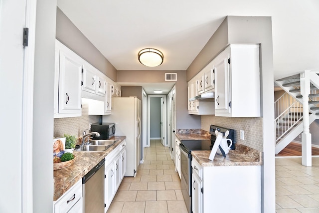 kitchen with sink, light tile patterned floors, stainless steel appliances, and white cabinets