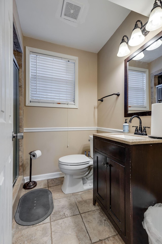 bathroom featuring tile patterned flooring, an enclosed shower, vanity, and toilet