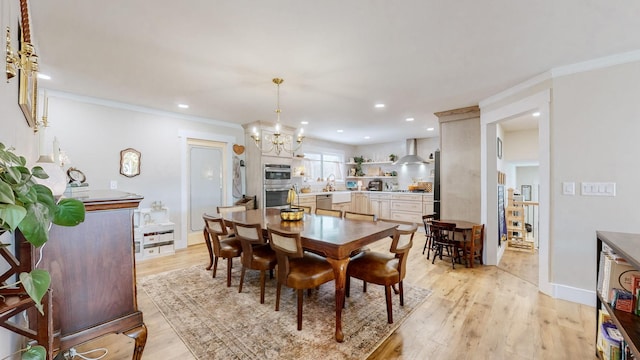 dining room with ornamental molding, a notable chandelier, and light hardwood / wood-style flooring