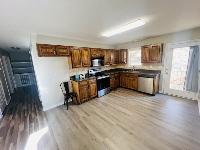 306 Turkey Creek Hwy, Carthage, TN 37030 - kitchen with tasteful backsplash, appliances with stainless steel finishes, sink, and light hardwood / wood-style flooring