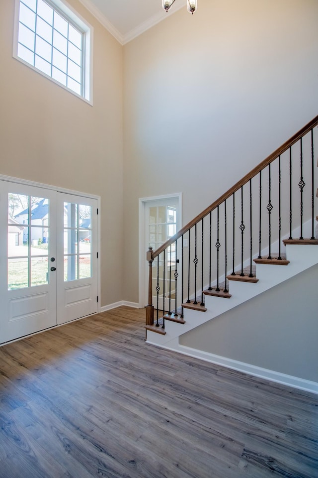 entryway with ornamental molding, a healthy amount of sunlight, french doors, and hardwood / wood-style flooring