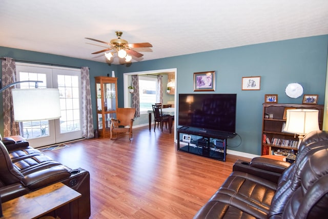 living room with french doors, ceiling fan, and light hardwood / wood-style flooring