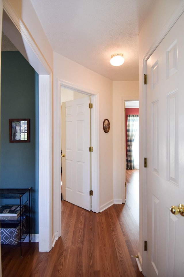 hall featuring a textured ceiling and hardwood / wood-style floors