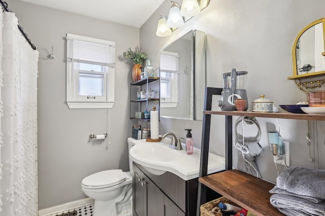 bathroom featuring a wealth of natural light, vanity, and toilet