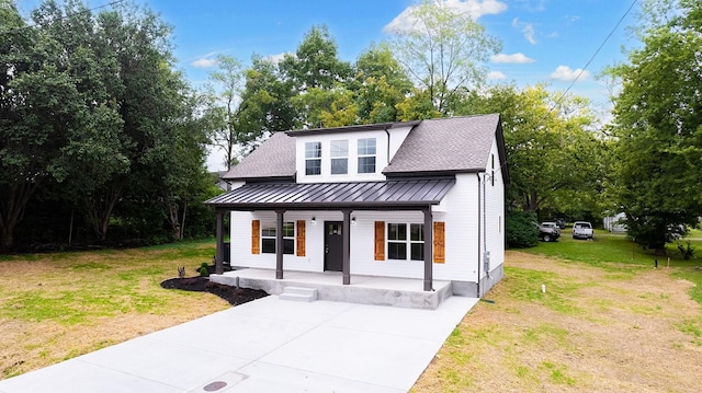 modern farmhouse style home with covered porch and a front lawn