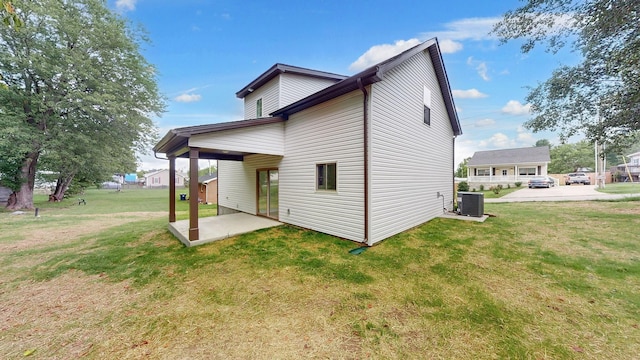 back of property with a patio, a yard, and central AC unit