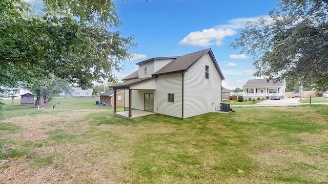 rear view of house with a patio and a lawn