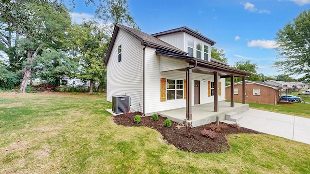 view of front of home with central air condition unit, a front lawn, and a porch