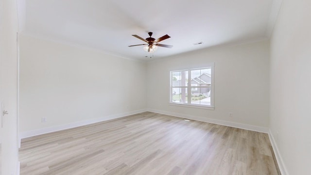 empty room with ornamental molding, ceiling fan, and light hardwood / wood-style flooring