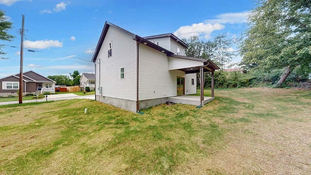 view of side of property featuring a lawn and a patio area