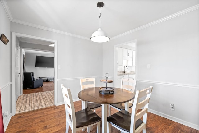 dining room featuring sink, dark hardwood / wood-style floors, and ornamental molding