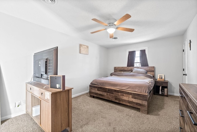 bedroom with ceiling fan, light carpet, and a textured ceiling