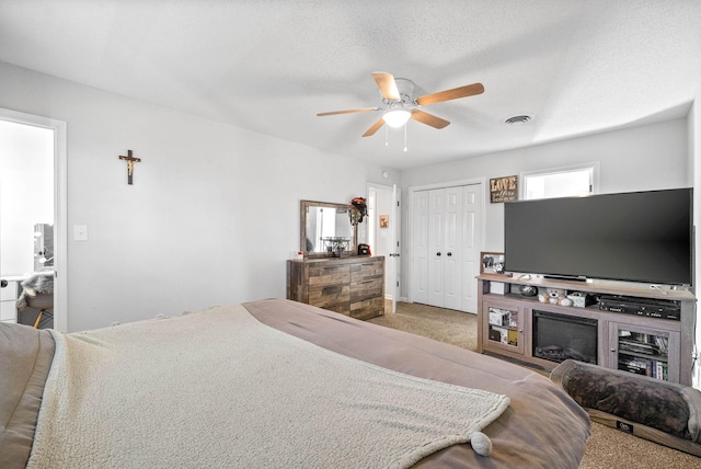 bedroom featuring a textured ceiling, ceiling fan, and carpet floors