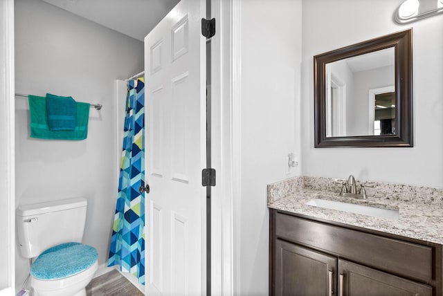 bathroom with curtained shower, hardwood / wood-style floors, toilet, and vanity